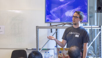 Louis Hoebregts speaking in front of an audience wearing a CodePen tshirt
