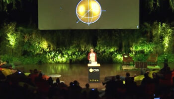 Louis Hoebregts speaking in front of an audience on a jungle themed stage. On the screen behind, a Christmas decoration with CSS Christ Math written above.